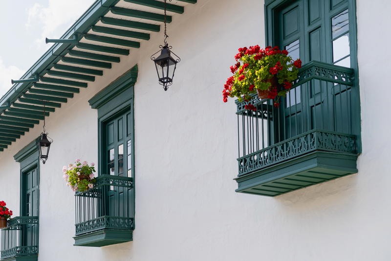 A white building with green shutters and flower boxes