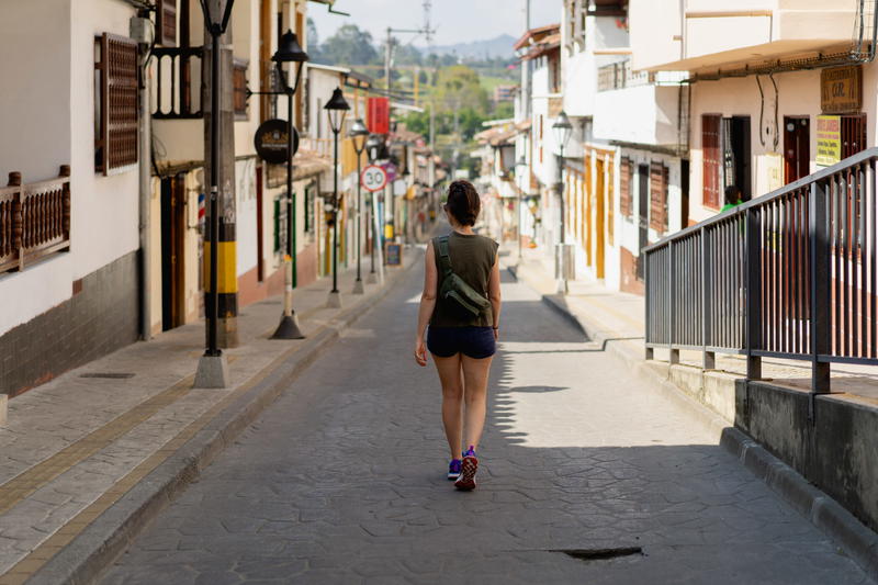 A woman walking down a street in a town