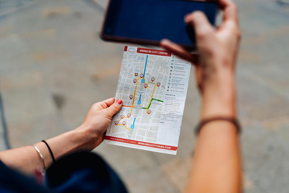 A woman holding up a map on her cell phone.