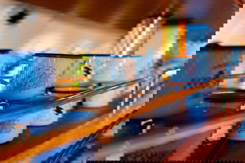 A row of blue and white mugs on a shelf.