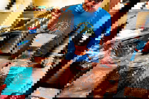 A man pouring coffee into jars.