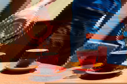 A person pouring coffee into a cup.