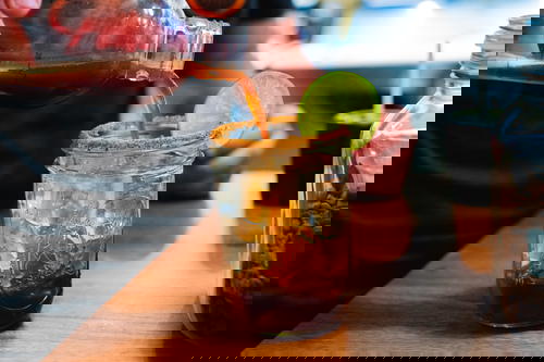 A person is pouring a drink into a mason jar.