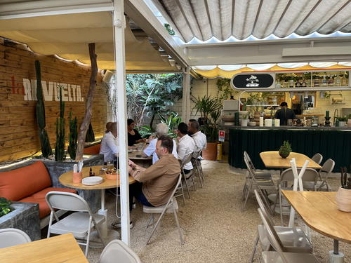 a group of people sitting at tables in a restaurant