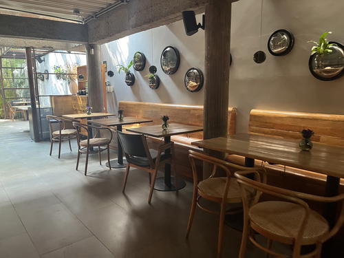 a restaurant with tables and chairs and a wall of mirrors