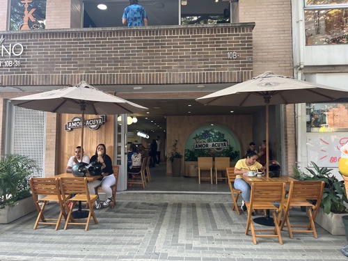 a group of people sitting at tables under umbrellas