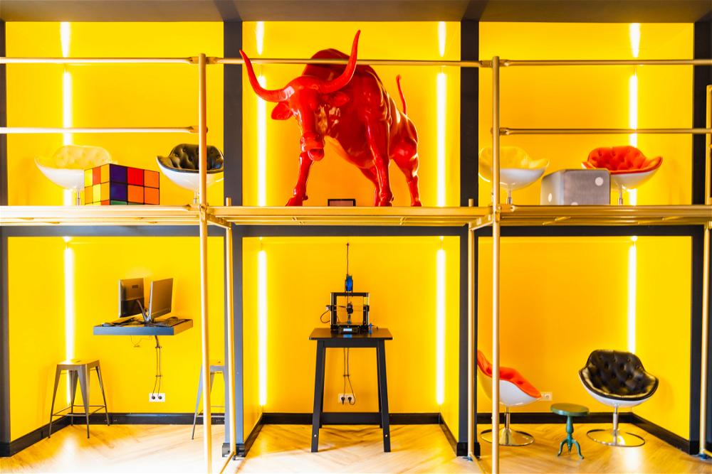 A room with yellow walls and a bull statue.