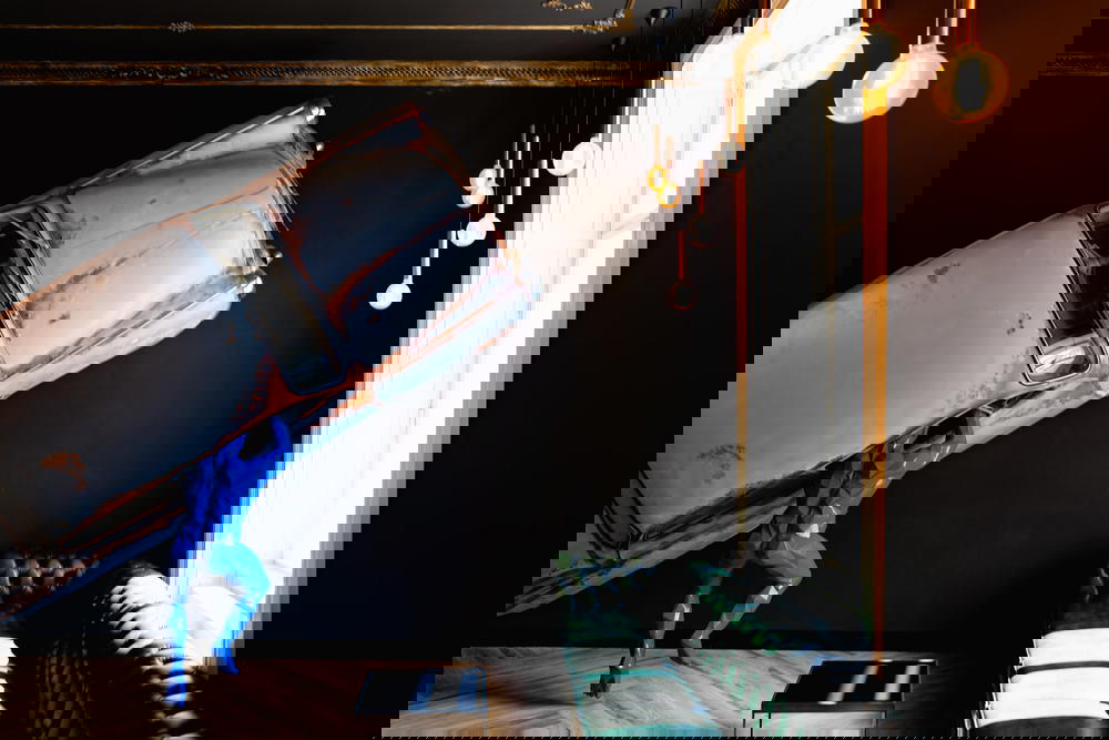 Blue man statue climbing into life-size car replica on the wall of the lobby