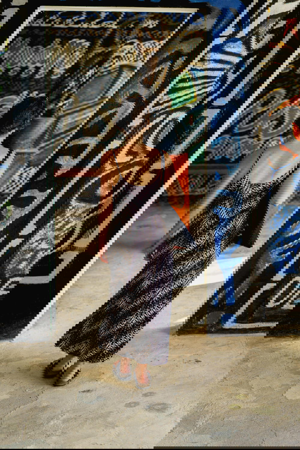 Girl walking through rooms covered in graffiti style painted wall art at Castillo Mundo King