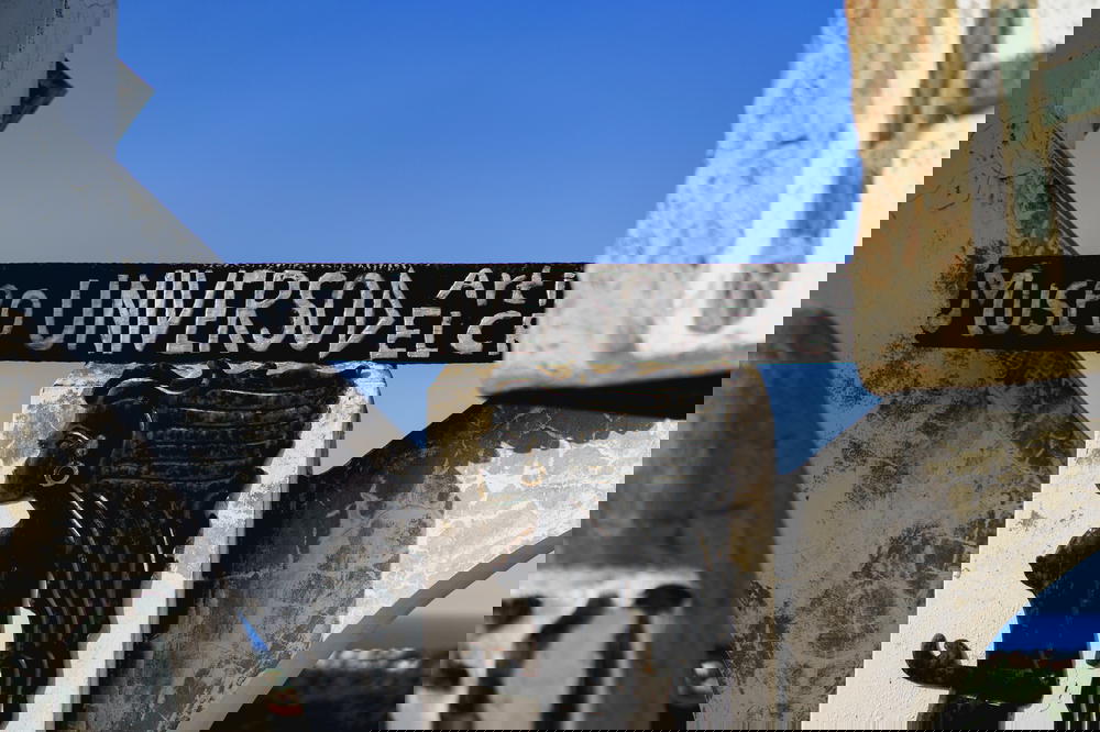 Museo Universo hand carved sign on white concrete at Castillo Mundo King against a perfect blue sky