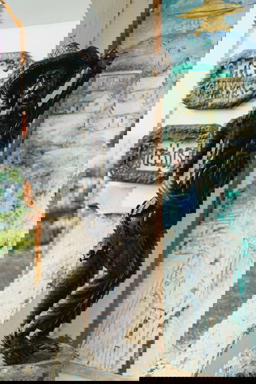 A statue of a man holding a guitar in front of a building.