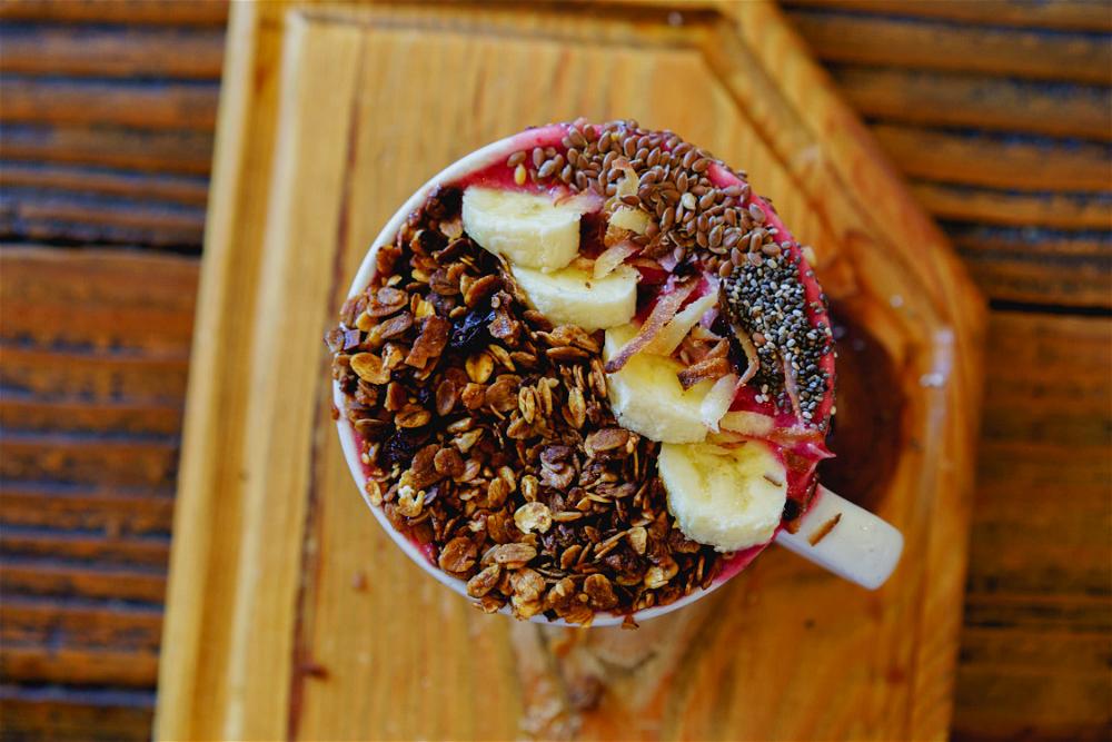 Smoothie bowl with oat granola, sliced banana, flax and chia seeds