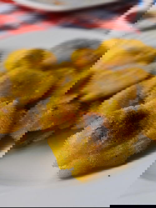 Tostones or fried smashed plantains on a white plate
