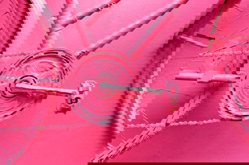 Pink bicycle gears and wheels on a painted wall on Pink Street in Puerto Plata Dominican Republic
