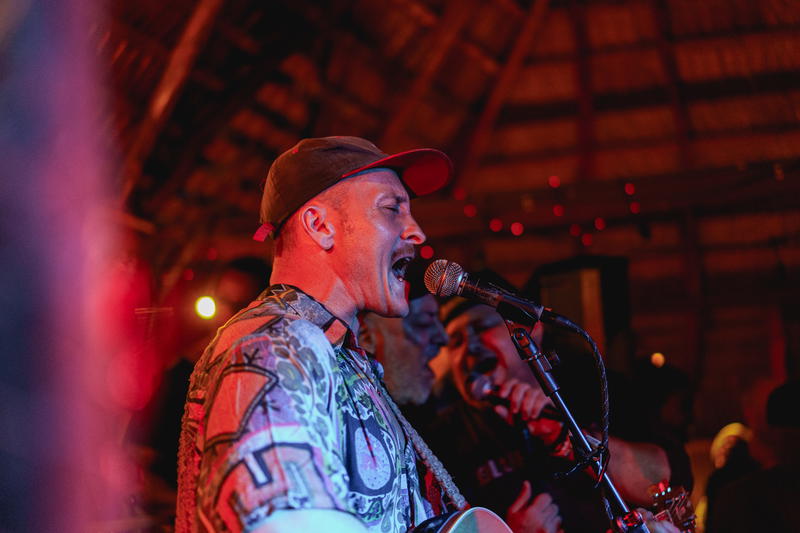 Man singing and playing acoustic guitar at open mic night La Chabola Cabarete Dominican Republic expat scene