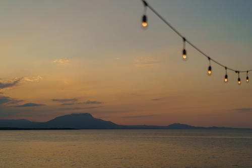 A string of lights hanging over a body of water.
