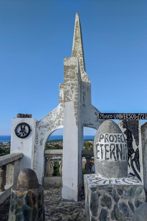A monument on top of a hill overlooking the ocean.