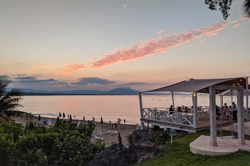 A gazebo overlooking a beach at sunset.