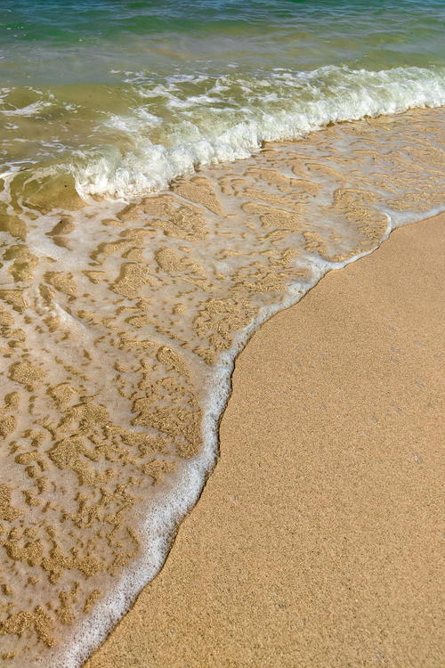 A beach with waves and sand.