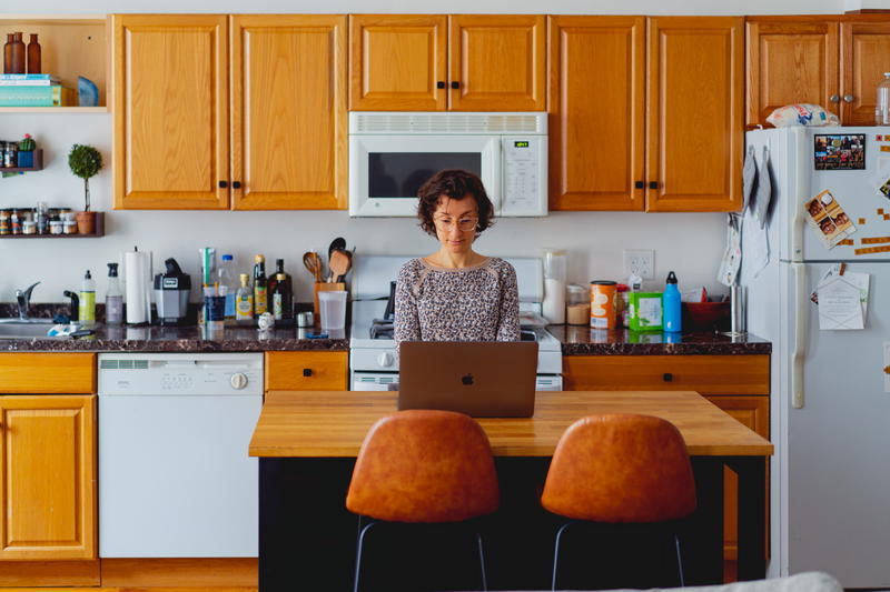 Woman working with a laptop in a kitchen