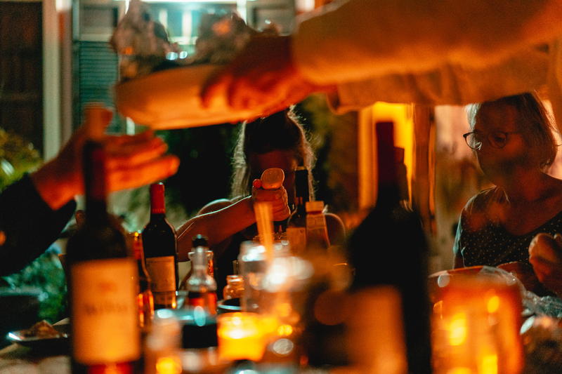 A group of people are pouring wine at a table.