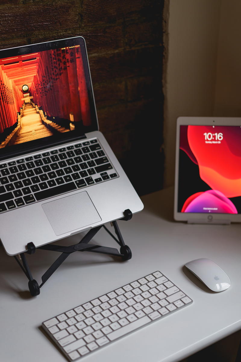 A laptop sits on a desk next to a mouse and keyboard.