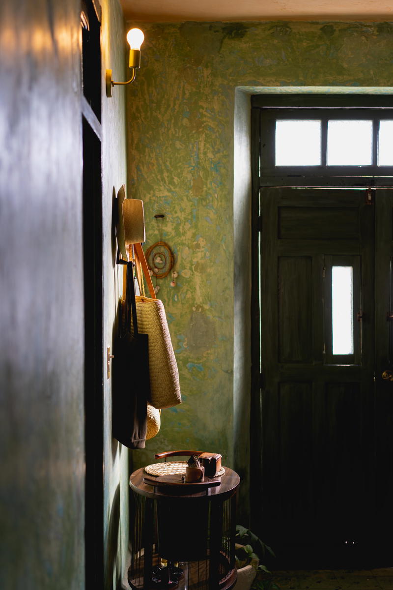 A room with a green wall and a black door.