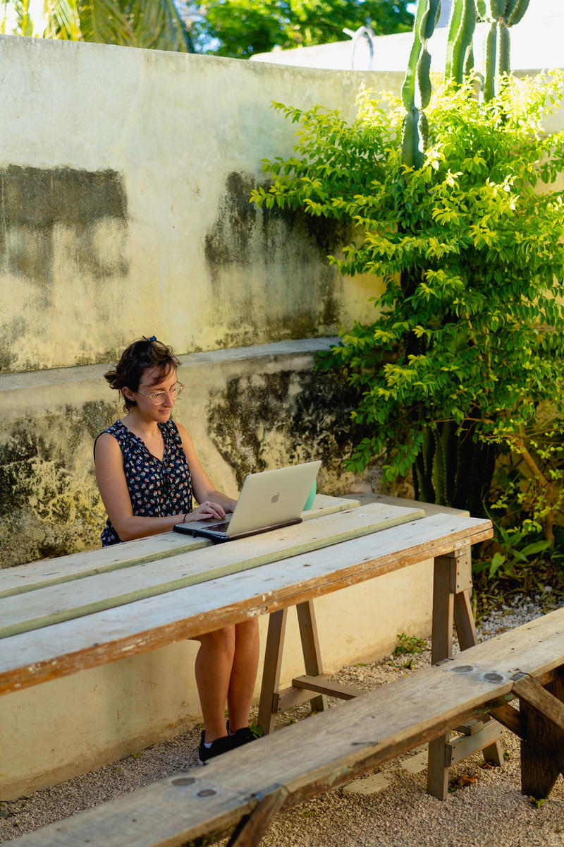 A woman sitting at a table with a laptop.