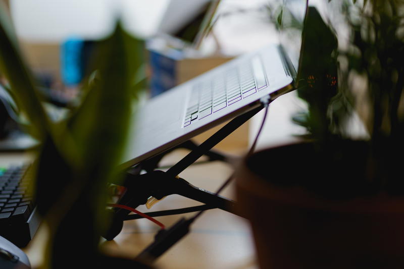 MacBook Pro being used on the Roost laptop stand in a standing desk home office setup with plants