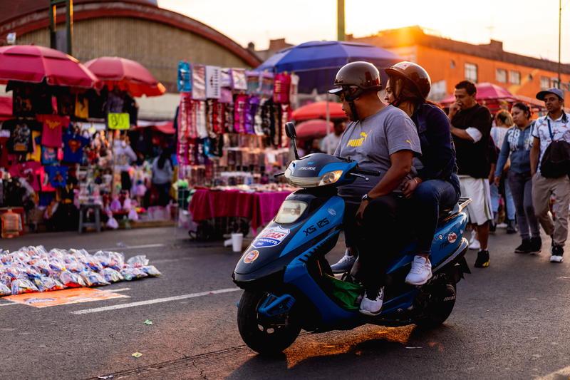 Two people on a scooter.