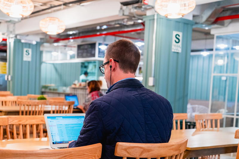 A man sitting at a table with a laptop.