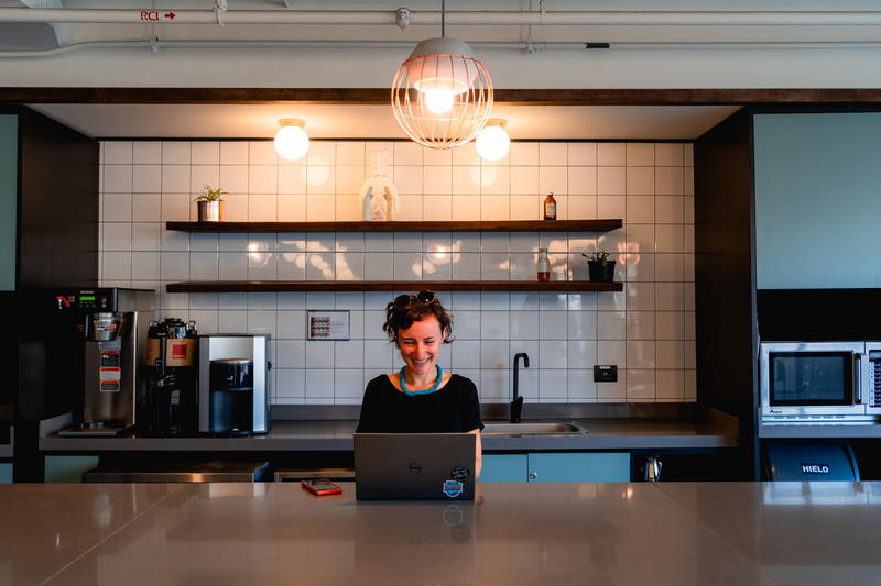 A woman sitting at a counter with a laptop.