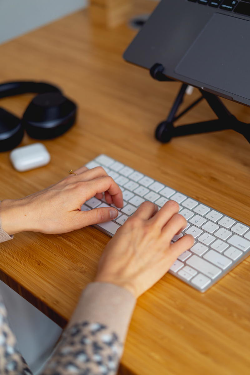 A woman typing on a computer keyboard.
