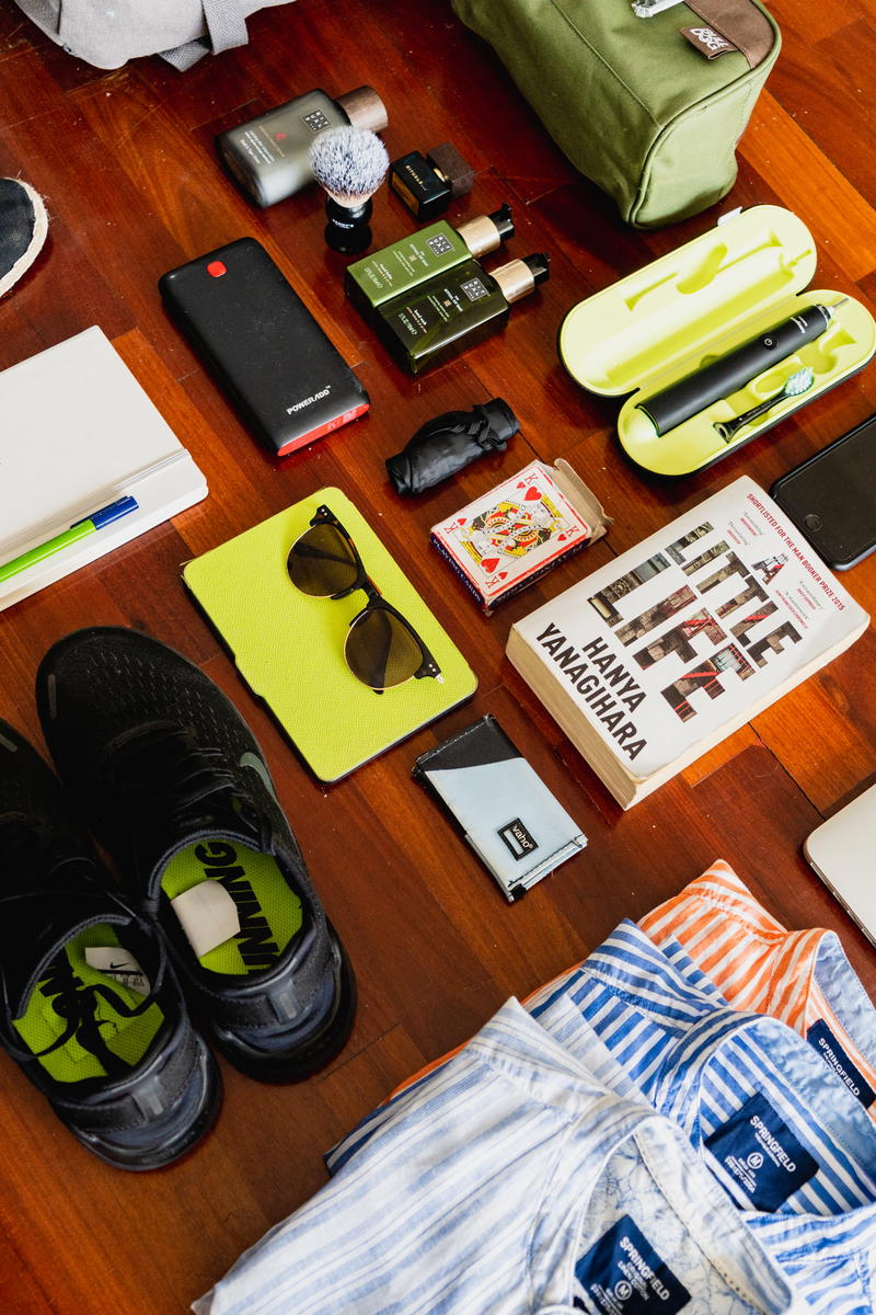 A backpack with a pair of shoes and a pair of flip flops.