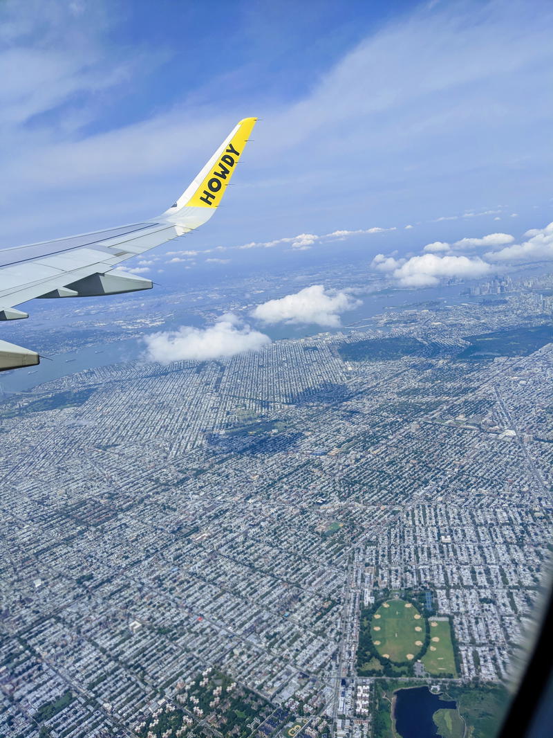 A view of a city from the wing of an airplane.