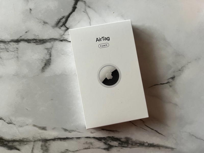 A white box with a black logo sitting on top of a marble table.