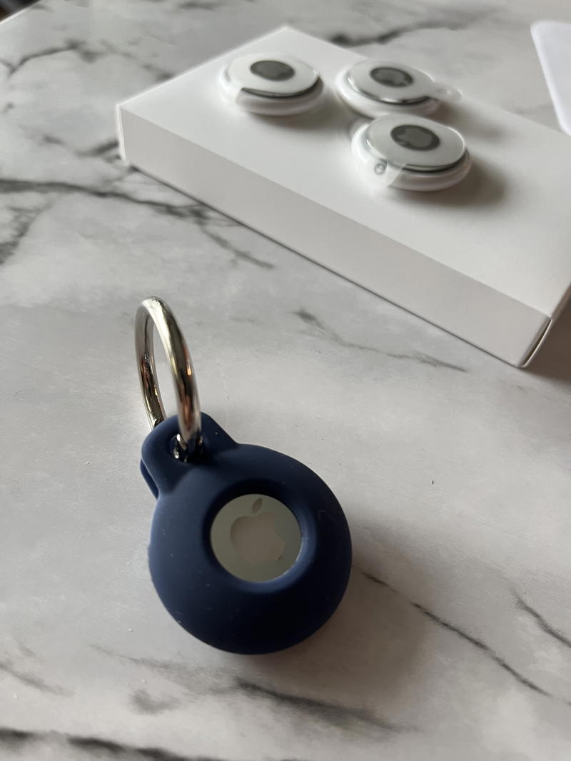 A blue key ring on a marble table.