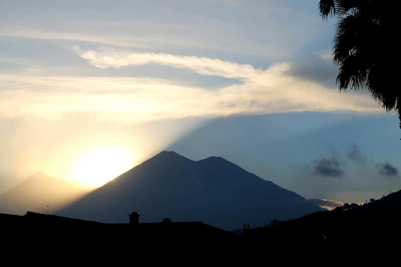 The sun is setting behind a mountain.