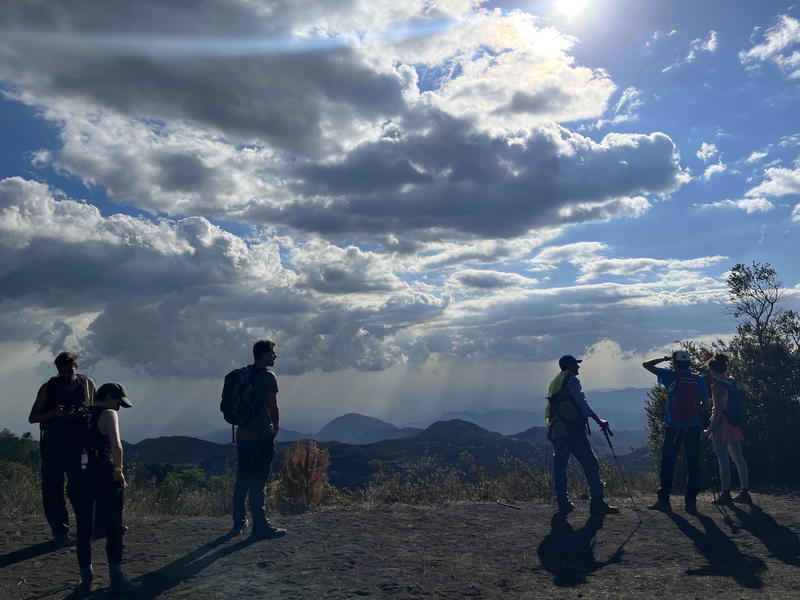 A group of people standing on top of a hill.