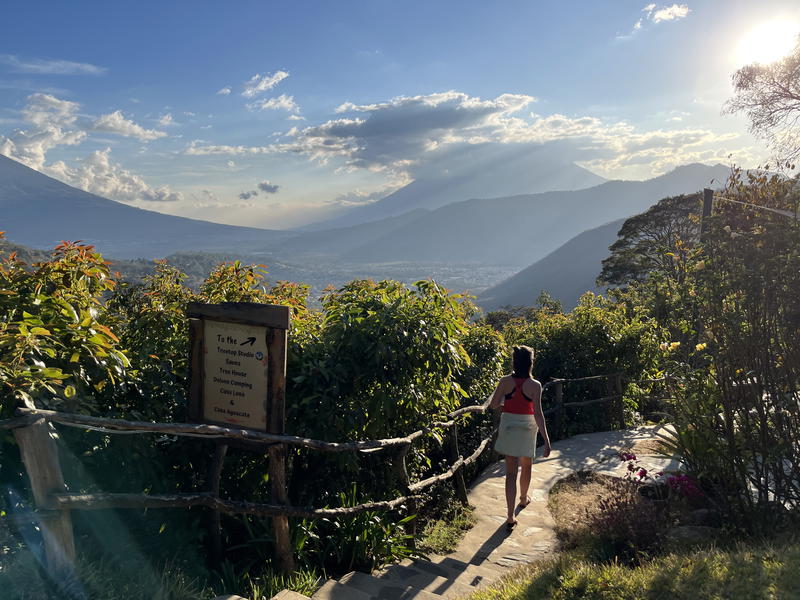 A woman walking down a path with mountains in Guatemala.