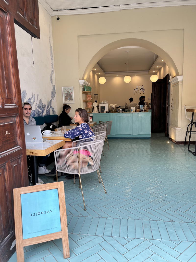 A group of people sitting at a table in a coffee shop.