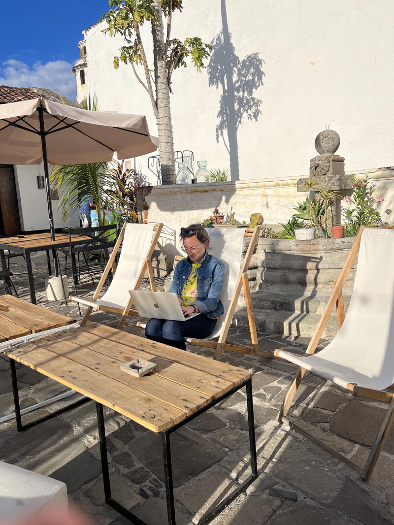 A woman using a laptop on a patio in Guatemala.