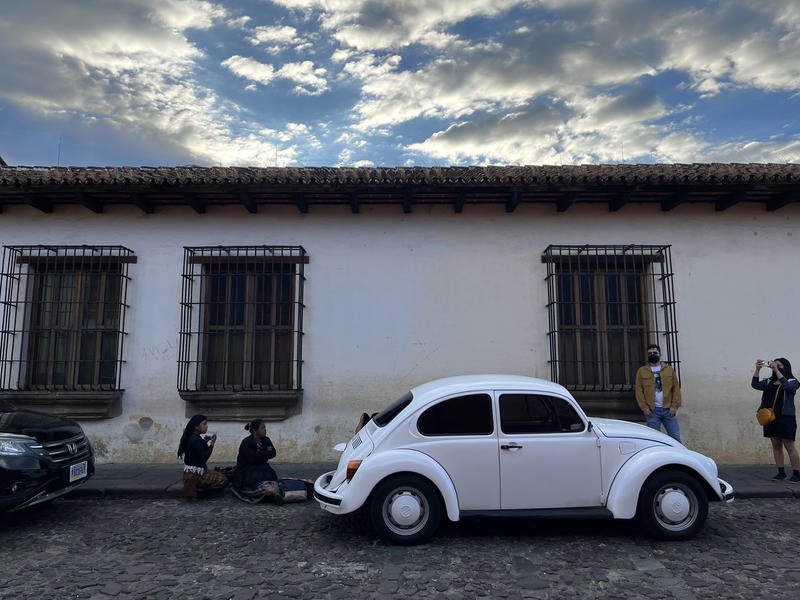 A Volkswagen beetle parked in front of a building in Guatemala.