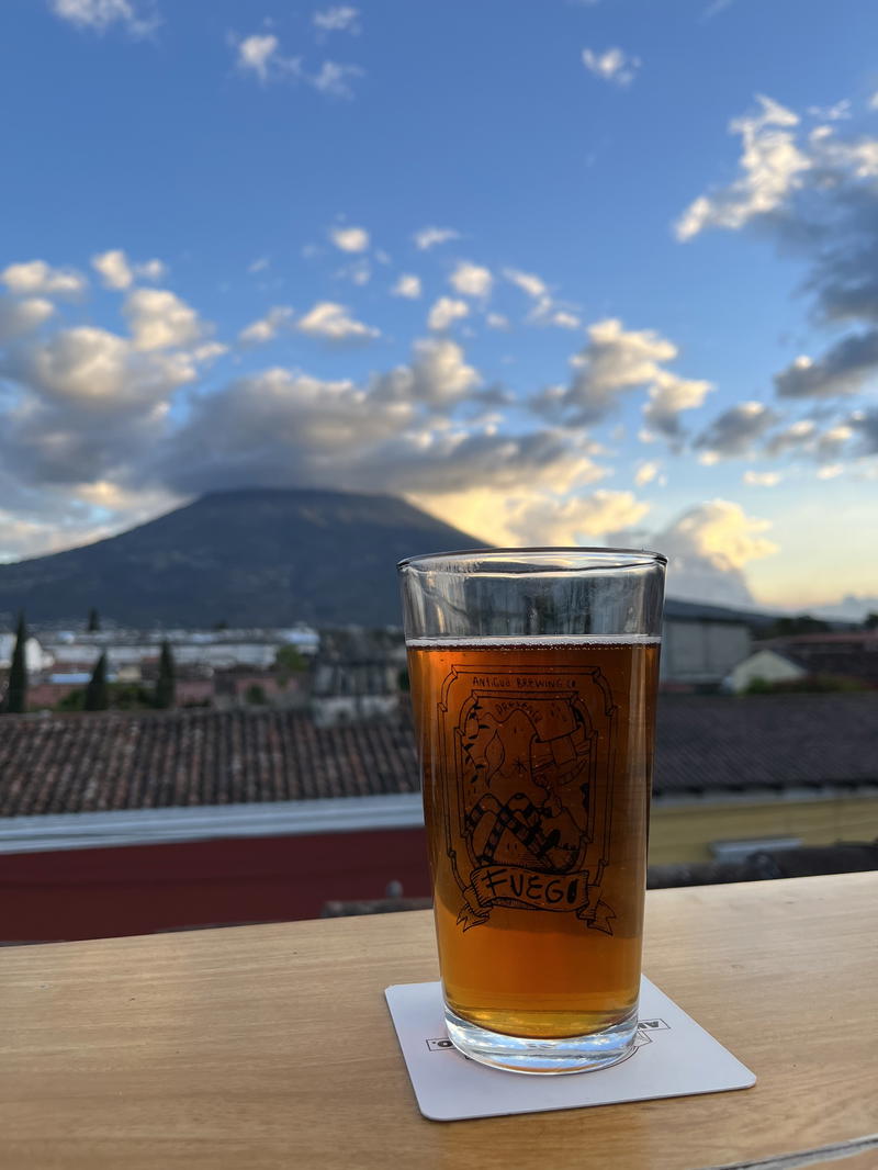 A glass of beer with a mountainous background in Guatemala.
