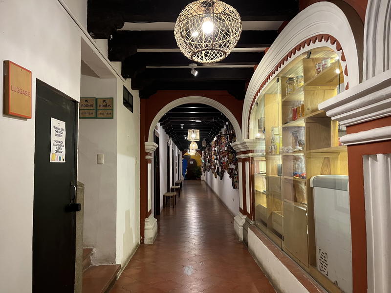 A hallway in Guatemala leading to a room with a chandelier.