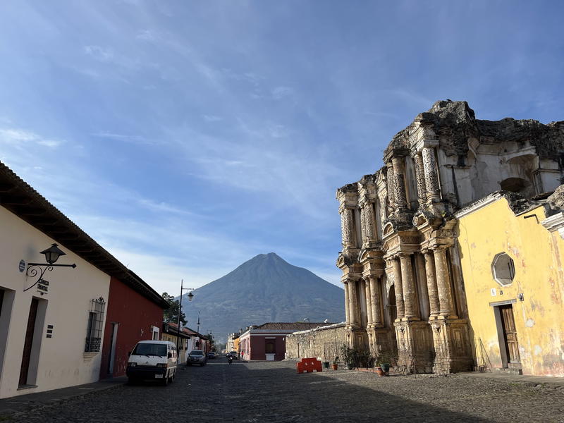 A cobblestone street in Guatemala with a mountain backdrop.