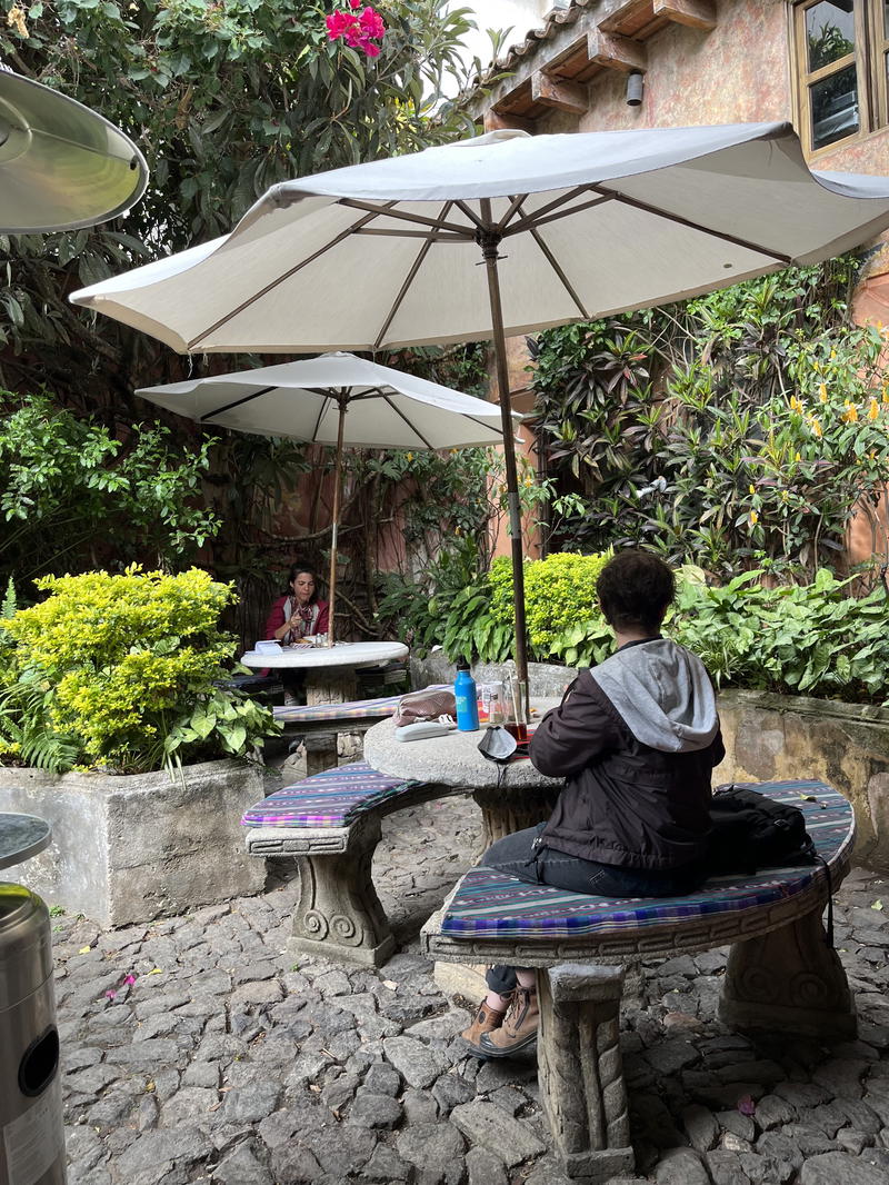 Two people sitting at a table under a white umbrella.