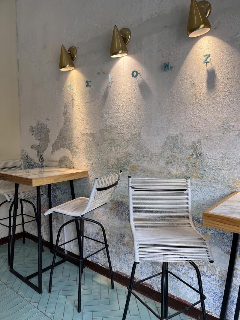 A cafe with tables and chairs on a tiled floor.