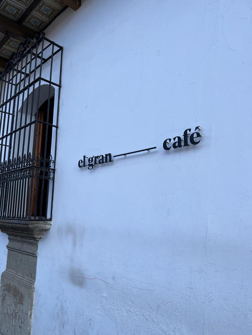 A sign on the side of a building in Guatemala that says iggan cafe.