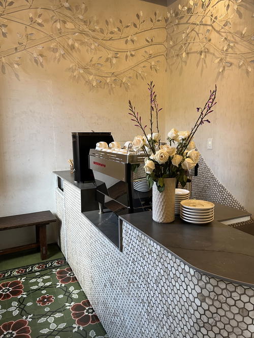 A coffee shop in Guatemala with a flower arrangement on the counter.
